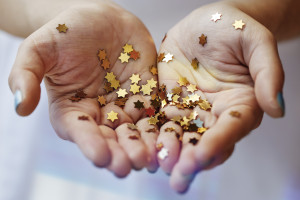 Girl holding gold star confetti